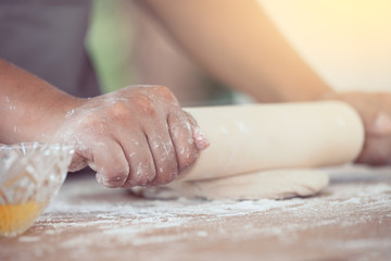 Woman hand preparing bread dough for baking cookies in the kitchen in vintage color tone