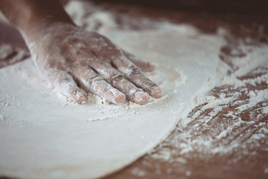 Woman hand preparing bread dough for baking cookies in the kitchen in vintage color tone