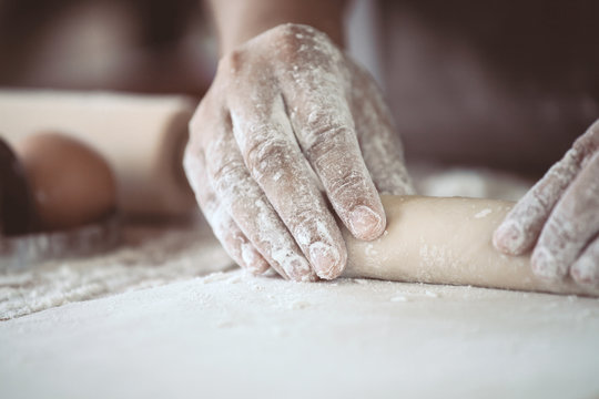Woman hand preparing bread dough for baking cookies in the kitchen in vintage color tone