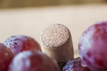 Blue grapes lie on a wooden background. Grapes macro. Grapes with droplets of water. Grapes in a cut. Grapes and wine corks. Blue and green grapes