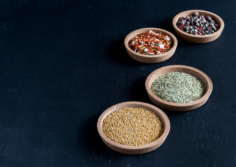 Spices in a small plates on black background Variety of spices Copy space Spice and herbs