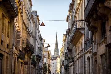 Fototapeta na wymiar Beautiful morning street view with old buildings and tower of saint Michel cathedral in Bordeaux city, France