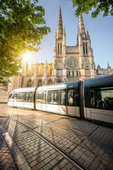 Morning view on the beautiful saint Pierre cathedral with modern tram in Bordeaux city, France