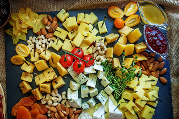 Different types of cheese with fruits, sauces and nuts. Italian snack. The concept of food.