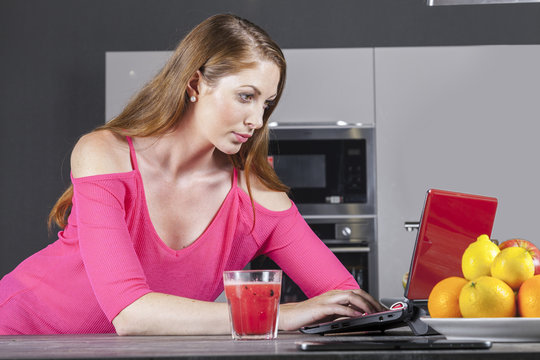hausfrau arbeitet am laptop in der küche