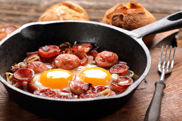 Cooked egg and sausages on frying pan