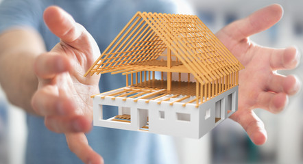 Businessman holding 3D rendering unfinished plan house in his hand