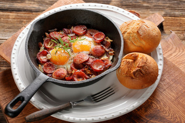 Cooked egg and sausages on frying pan