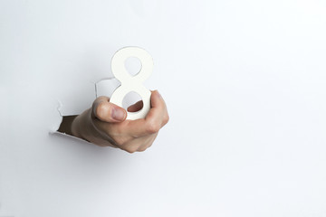 Female hand holding up the number eight a white background.