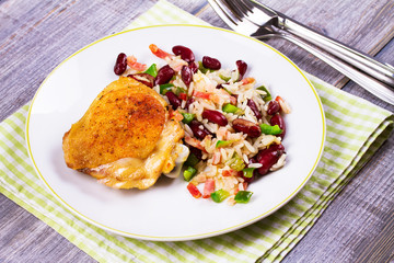 Chicken with Rice, Beans, Bacon and Green Pepper on White Plate. View from above, top studio shot