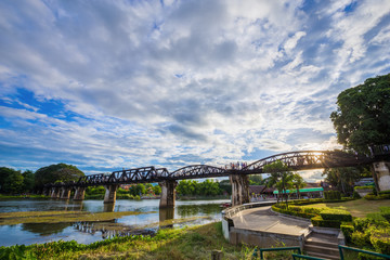 Fototapeta premium Bridge River Kwai with sky and sun in Kanchanaburi, Thailand