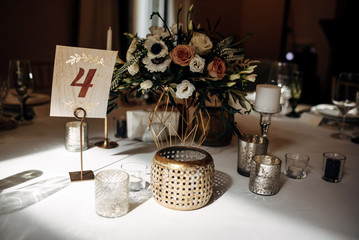 decorated table bride and groom with flasks for candles, flowers, candles and candlesticks and number of the table