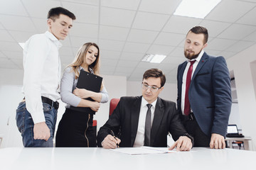 Portrait of confident employees looking at document at meeting