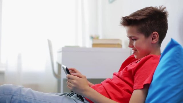 smiling boy with tablet pc computer at home