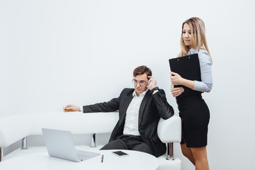 Elegant secretary bringing some documents for signature to her boss