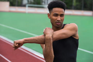 Handsome african athlete man make stretching exercises