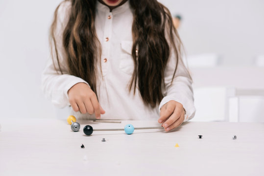 Cropped shot of schoolgirl working with molecular model at chemistry lesson