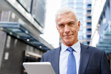 Senior businessman holding touchpad 