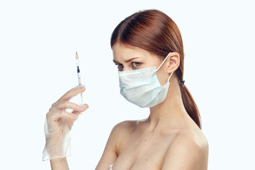 Young beautiful woman on white isolated background holds a syringe, medicine, nurse