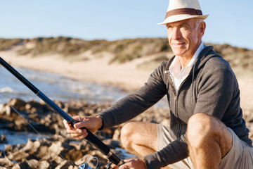 Senior man fishing at sea side