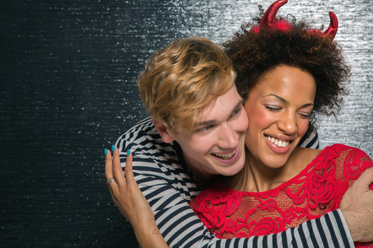 Couple embracing at Hallowwen party wearing costume outfits
