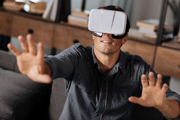 Charming energetic man testing newest VR gear