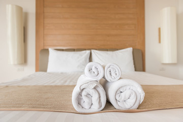 Towel rolls on a hotel bed.