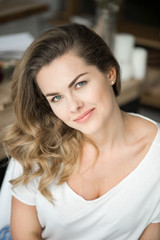 portrait of beautiful blonde woman in white clothes smiling at camera