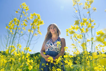 Naklejka na ściany i meble Cute woman in a yellow flowers field