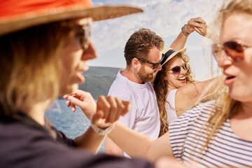 Group of people dancing, chatting and having a good time at beach party