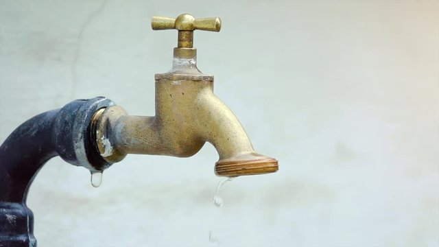 super slow motion shot of exterior tap water dripping and splash on a hot summer day