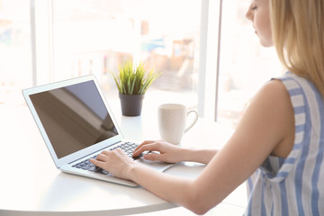 Young girl working with laptop in light room