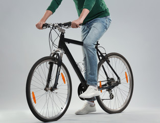 Fototapeta na wymiar Handsome young man with bicycle on light background