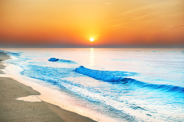 Obrazy na Plexi  Zachód słońca na plaży z długą linią brzegową