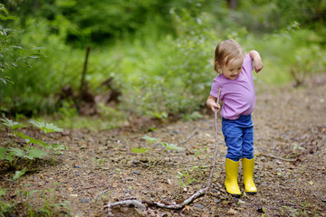 The little lovely girl walks on the wood.