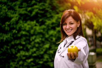 Female doctor offering apple