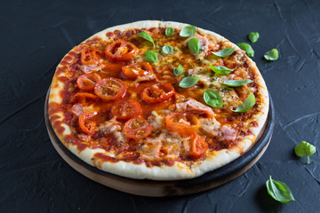 Pizza with tomatoes, ham and basil