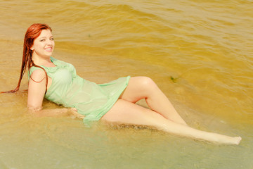 Redhead woman posing in water during summertime