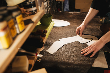 Young man shoemaker at footwear workshop.