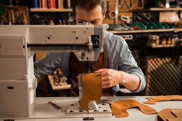 Man cobbler stitching leather patrs
