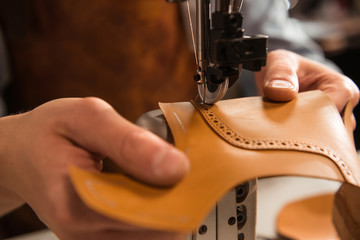 Close up of a cobbler stitching a part of shoe