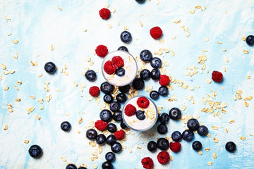 Sweet berry dessert with oatmeal, yogurt, blueberries and raspberries, top view