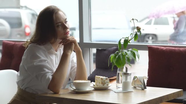 a young beautiful woman drinking coffee in a cafe. young woman in business clothes on a lunch break