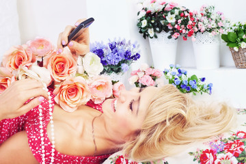 Happy woman with flowers texting message on phone
