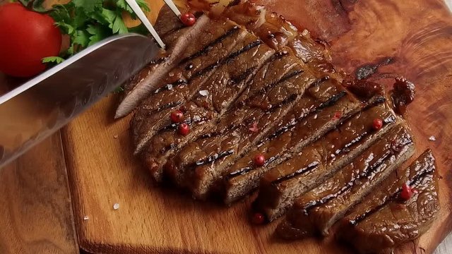 Beef steak on the board cut with a knife slow motion