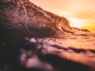 Wave in ocean and warm sun light. Sunset and wave