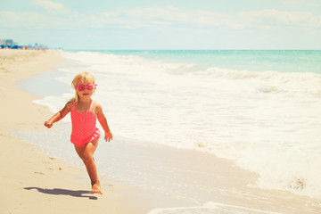 Fototapeta na wymiar happy cute little girl running on beach