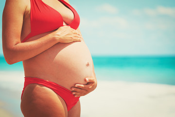 Fototapeta na wymiar Happy pregnant woman on beach