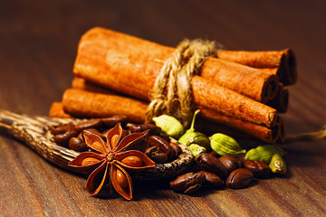Coffee beans with spices in the wooden spoon