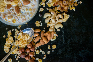 Healthy breakfast. Fresh granola, muesli with berries, honey in a glass jar on a black slate background.